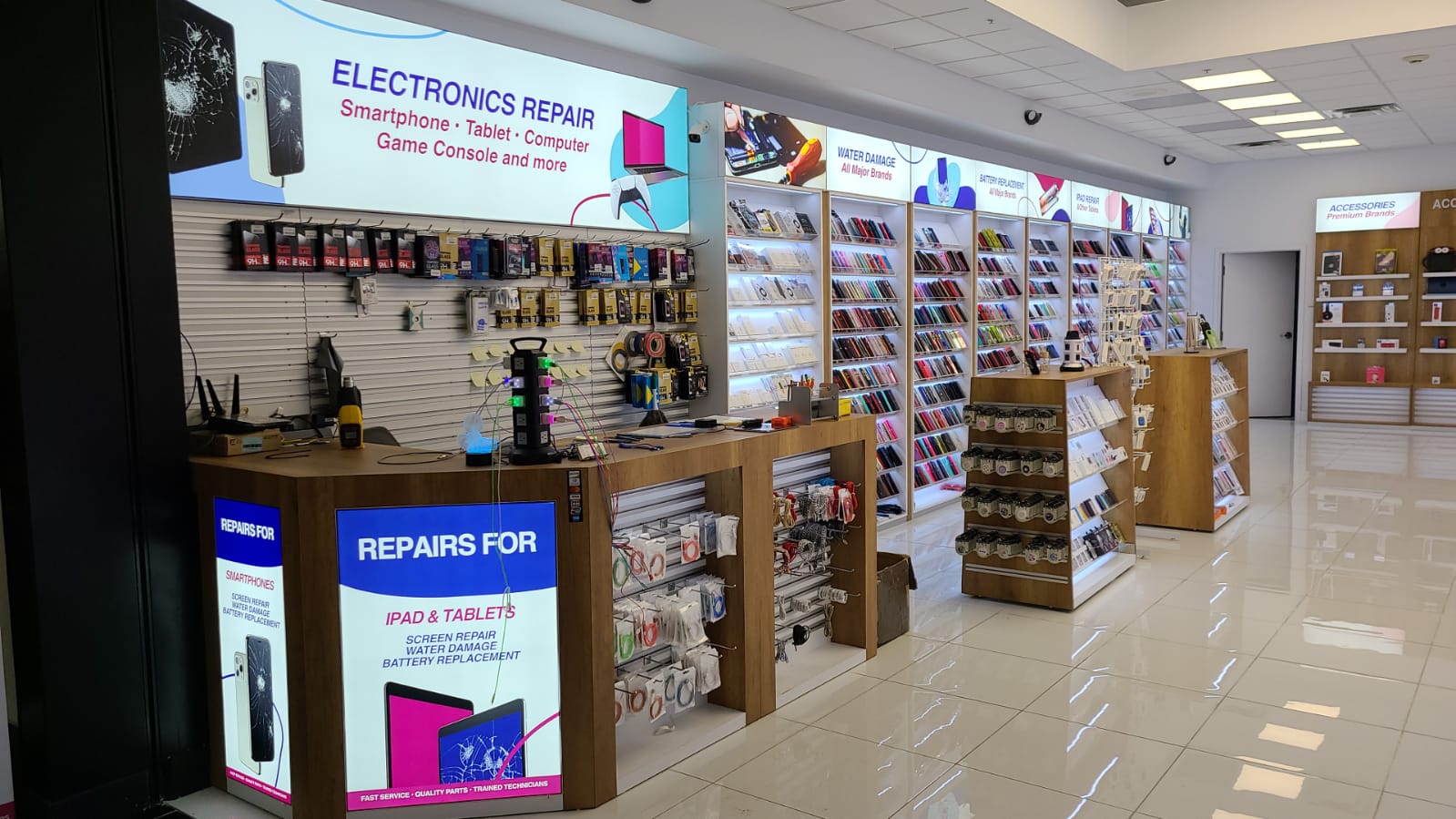 Construcción integral de la tienda The Fix por BD Display en St. Louis — pared de vitrinas iluminada, mostrador de reparación y mesas de accesorios